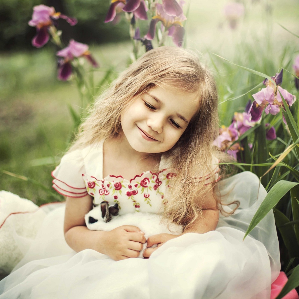 Маленькая девочка блондинка держит в руках кролика