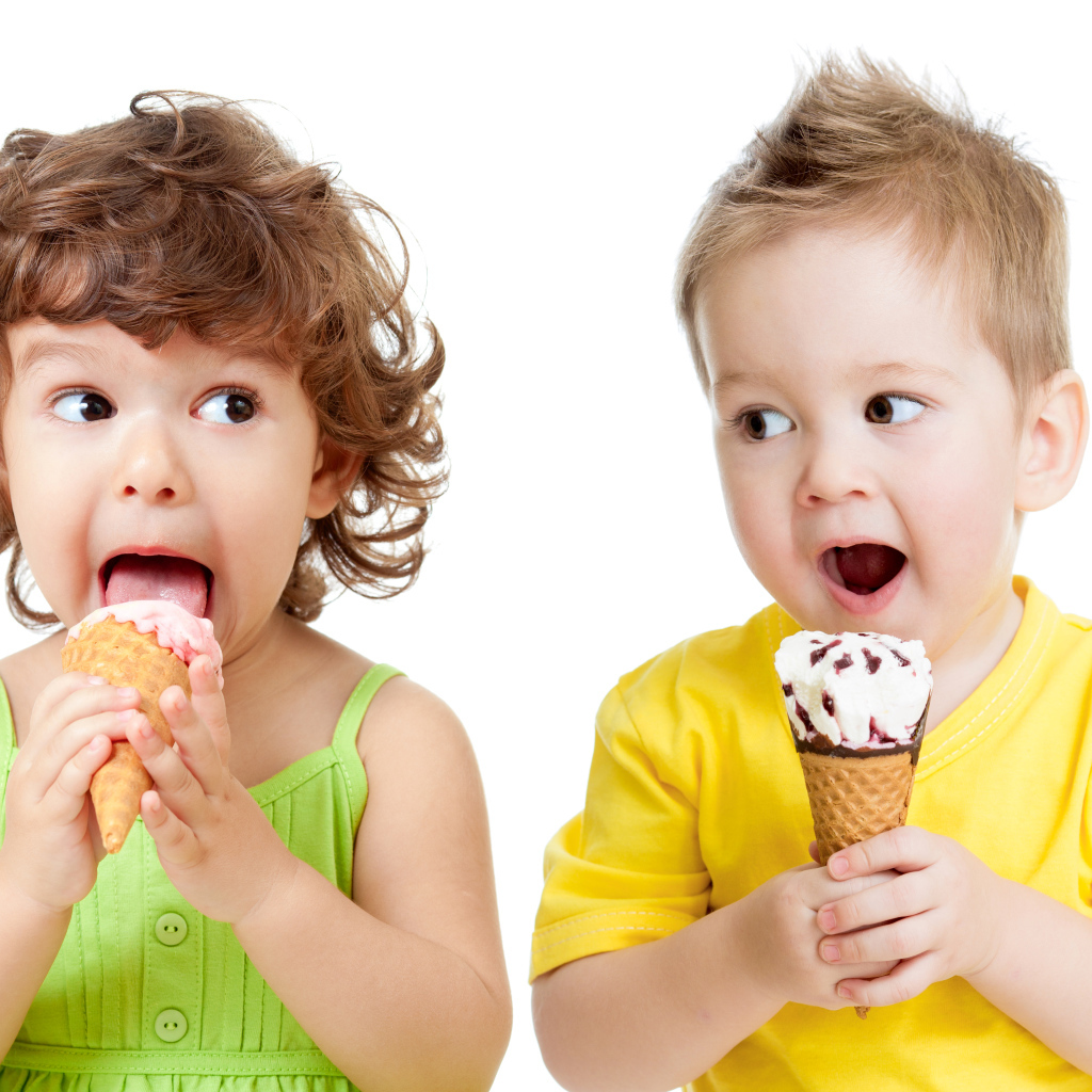 Маленькие мальчик и девочка едят вкусное мороженое