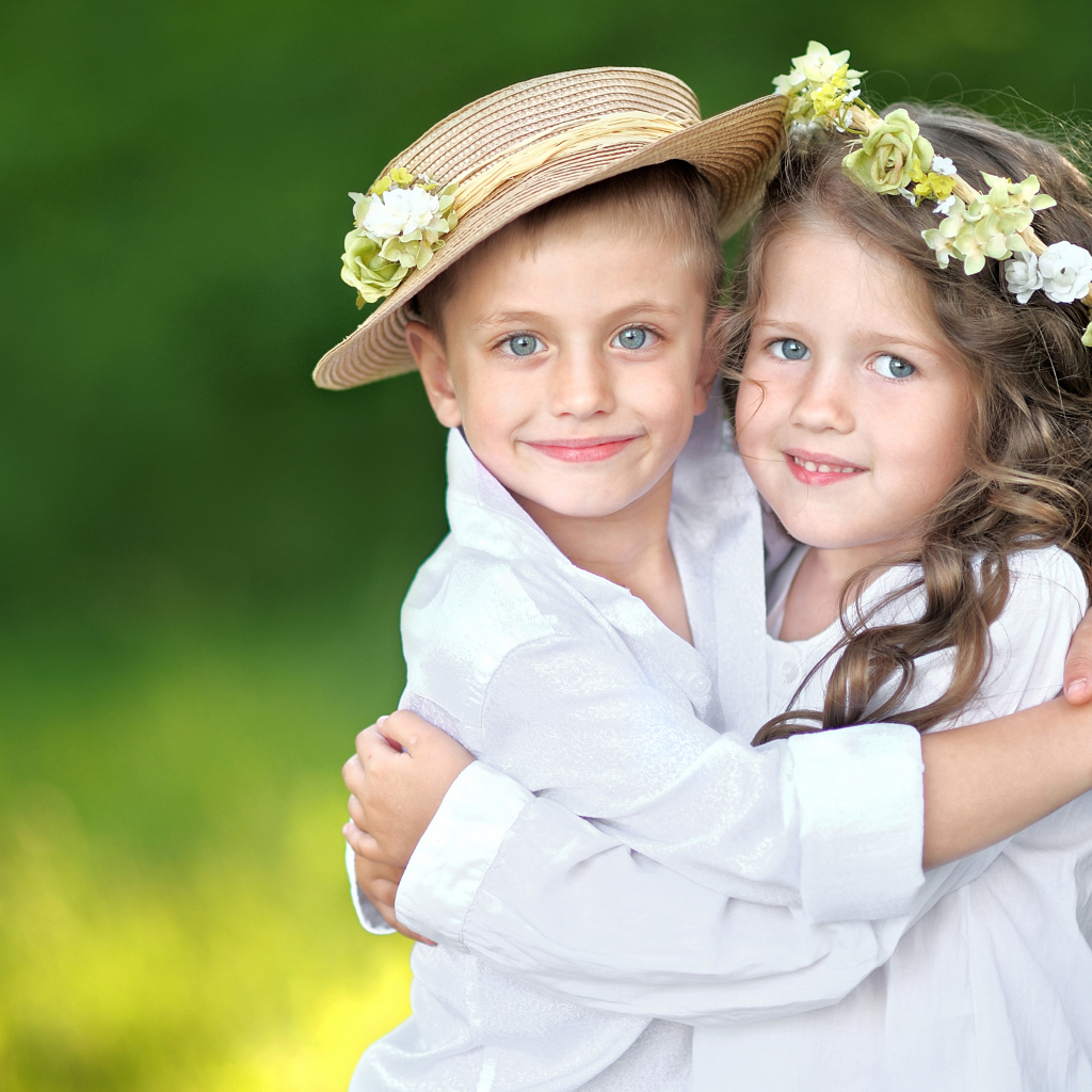 Маленькие мальчик и девочка обнимают друг друга