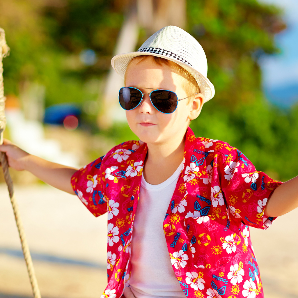 Маленький мальчик в белой шляпе и солнечных очках