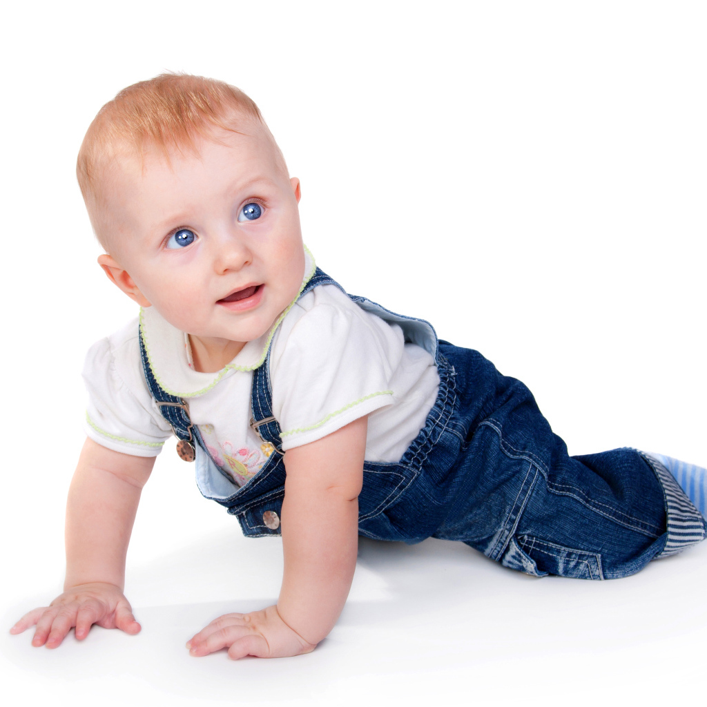 Маленький мальчик в синем комбинезоне на белом фоне