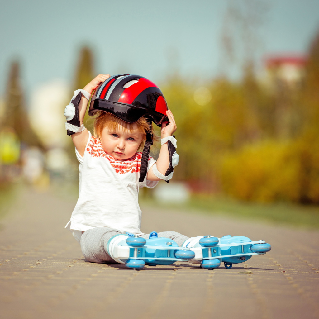 Маленький мальчик в шлеме и роликовых коньках