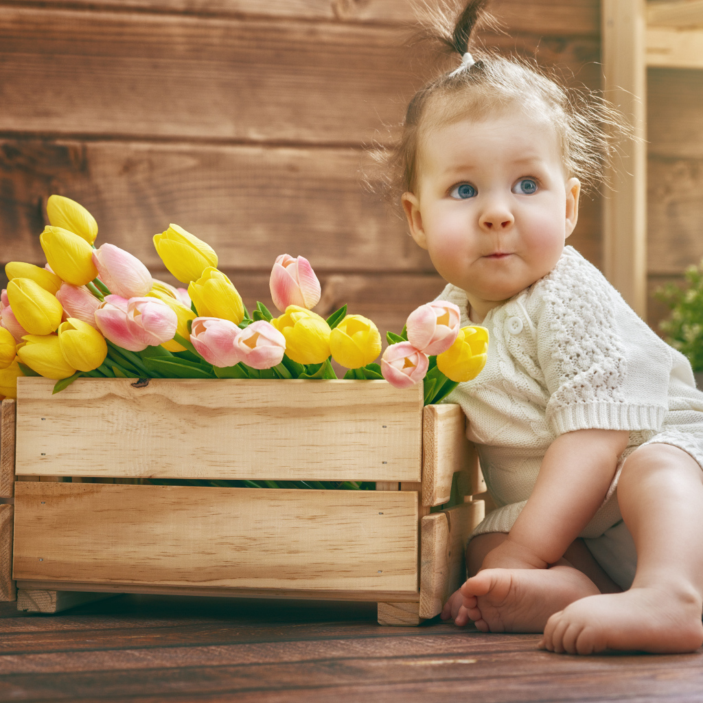 Маленькая забавная девочка с букетом тюльпанов