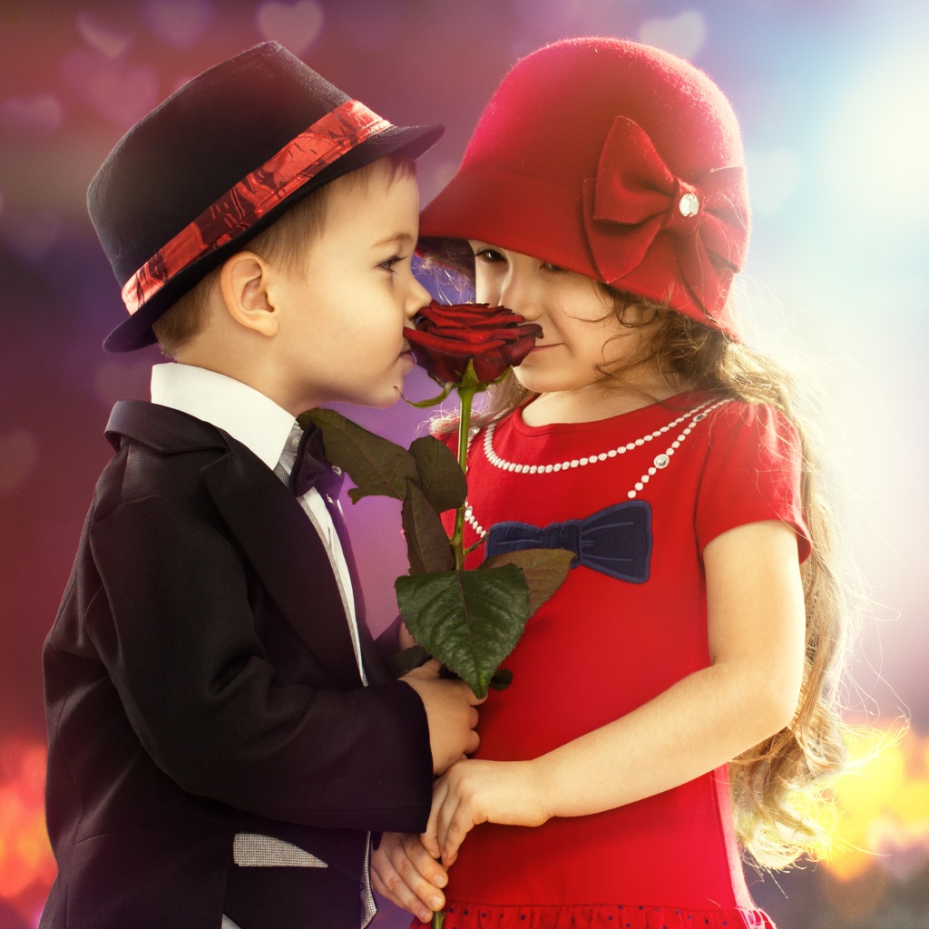 Маленькие девочка и мальчик с красной розой 