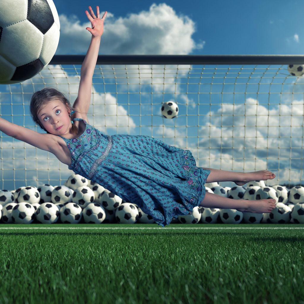 Маленькая девочка вратарь ловит мяч в воротах