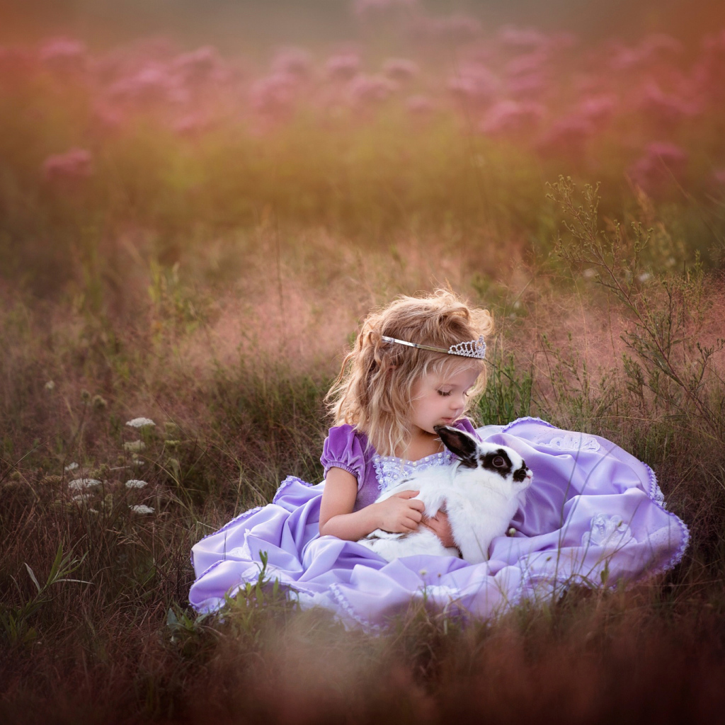 Маленькая девочка в красивом платье с кроликом в руках