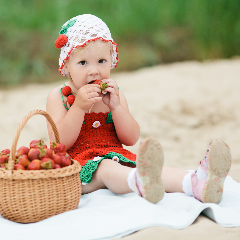 Маленькая девочка в большой корзиной клубники