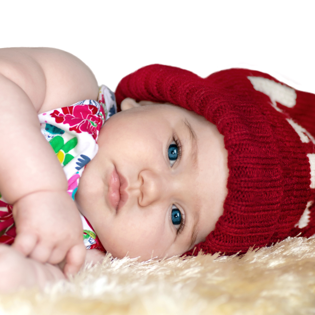 Маленькая девочка в красной вязаной шапке