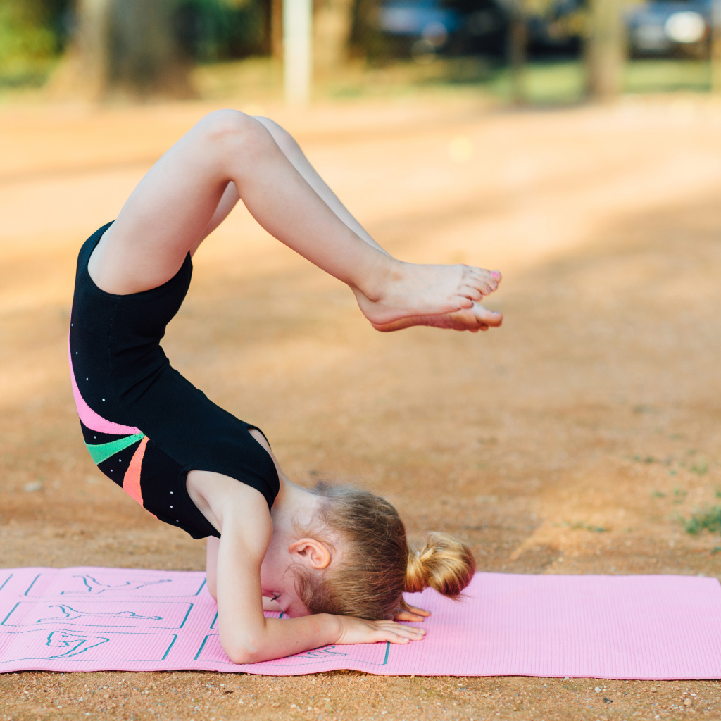 Маленькая девочка занимается гимнастикой