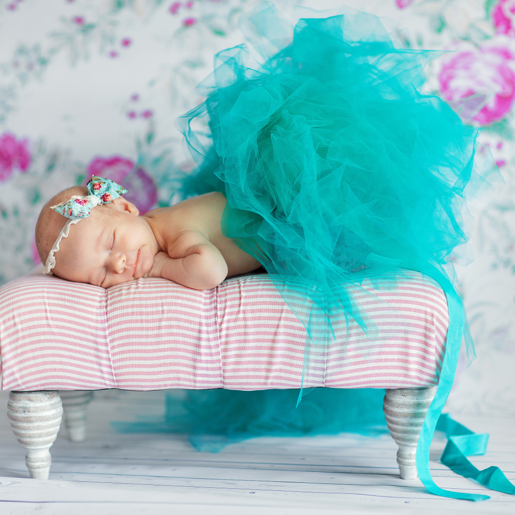 Маленькая девочка спит в красивом бирюзовом платье