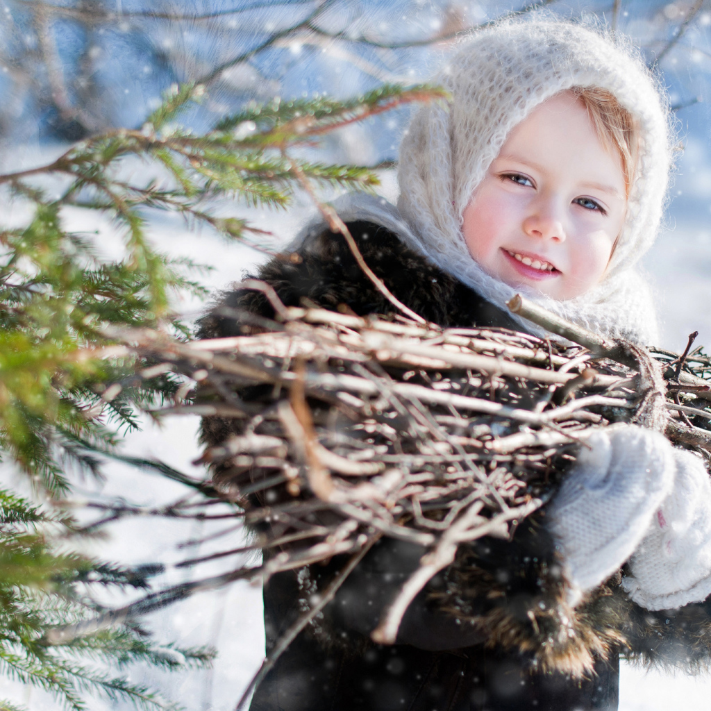 Маленькая девочка с пучком хвороста зимой