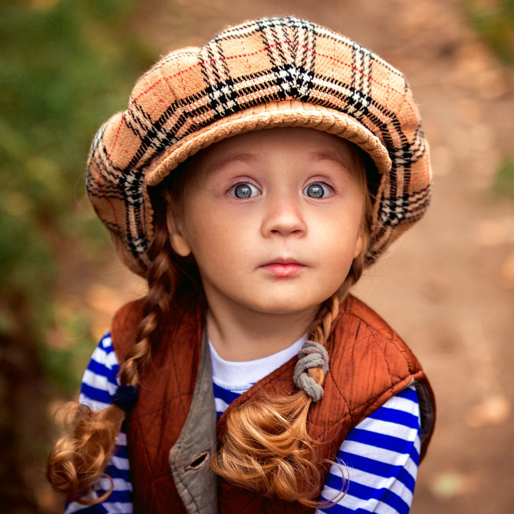 Маленькая рыжеволосая девочка в большой кепке