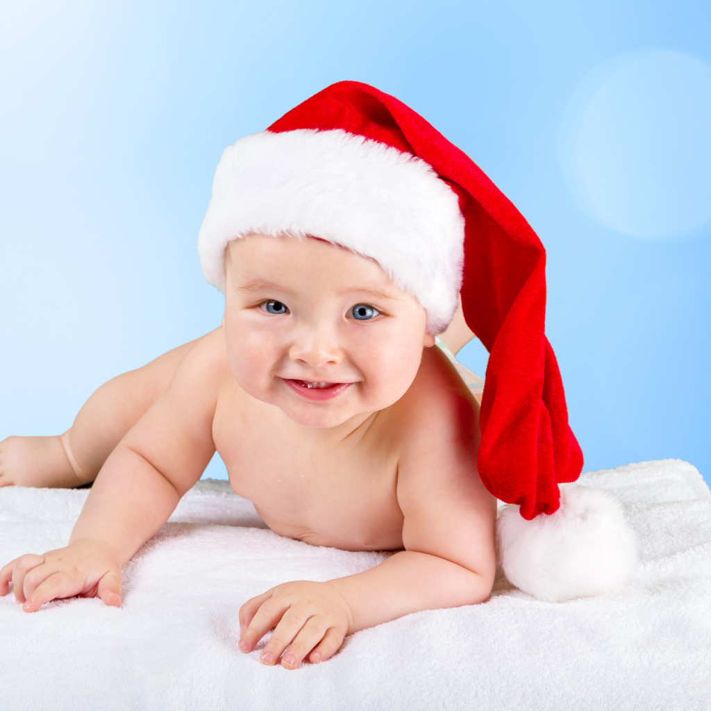 Улыбающийся грудной ребенок в новогодней шапке