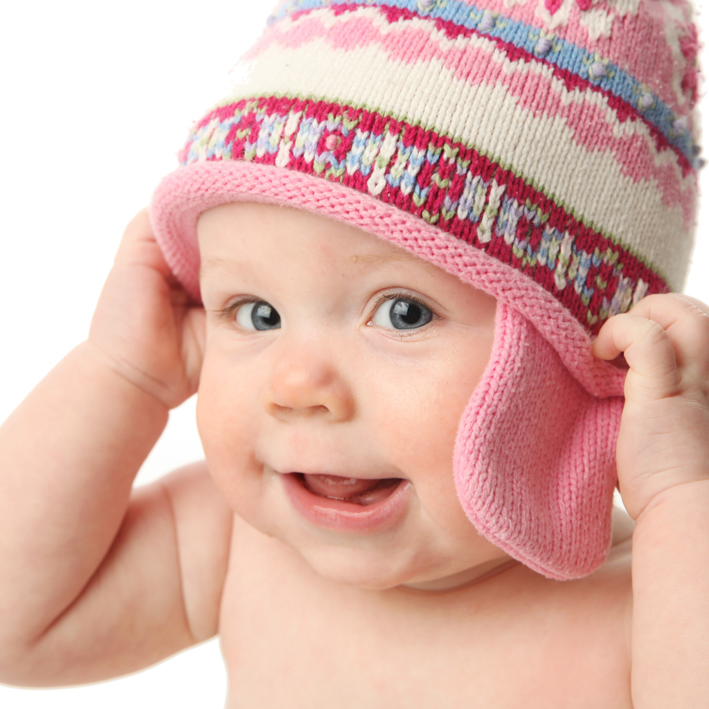 Улыбающийся ребенок в шапке на белом фоне