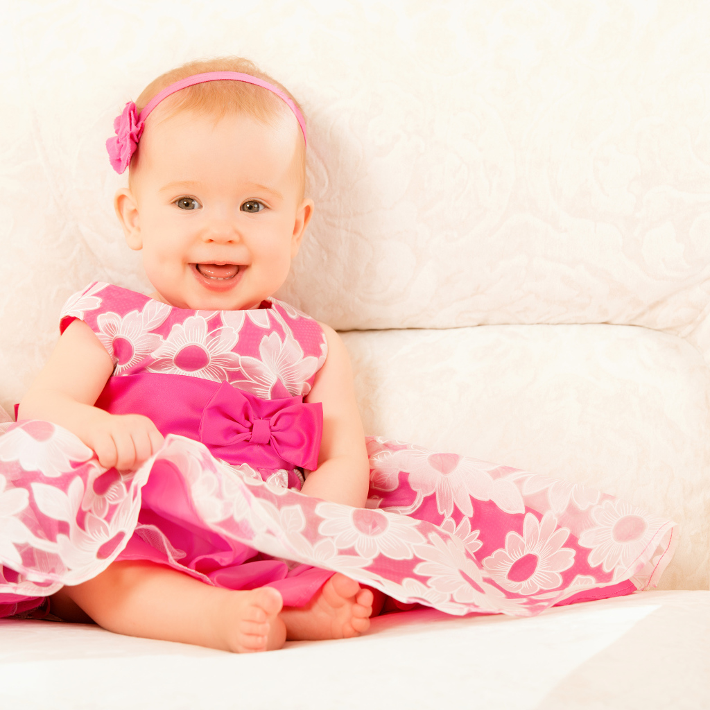 Улыбающаяся маленькая девочка в красивом розовом платье