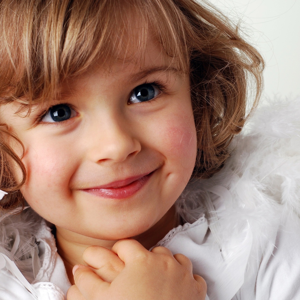 Маленькая голубоглазая девочка в костюме ангела 