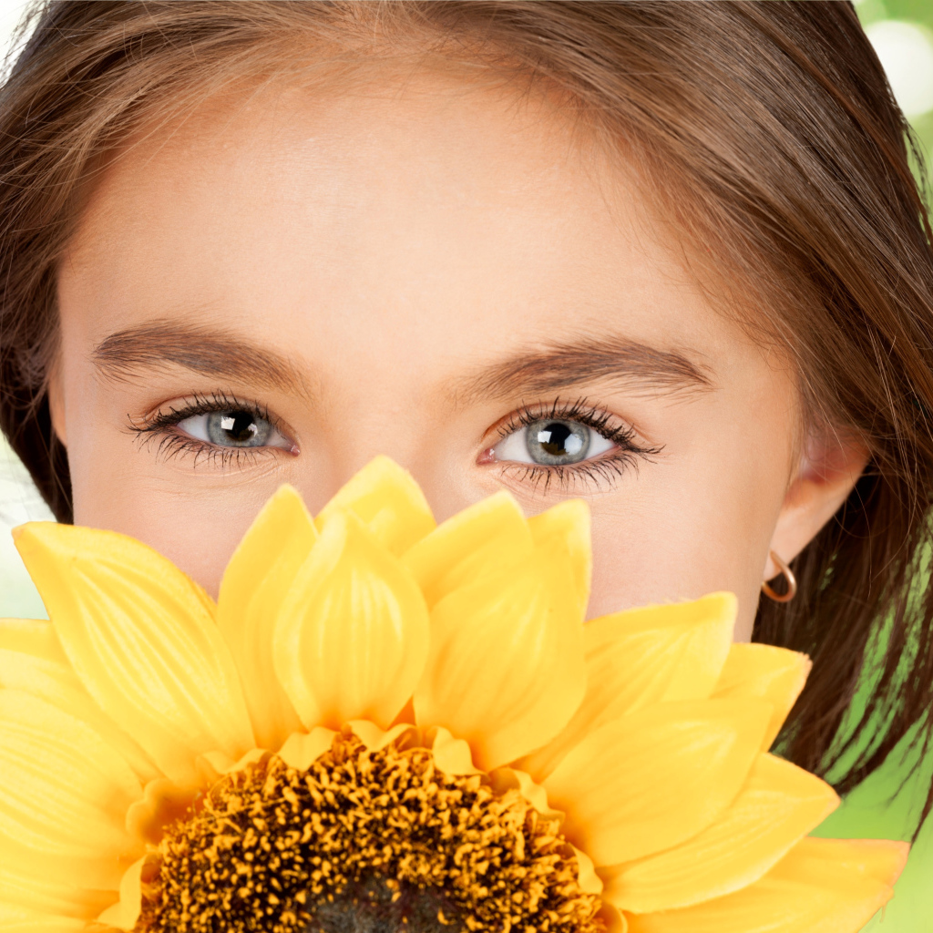 Взгляд маленькой девочки шатенки с подсолнухом в руках