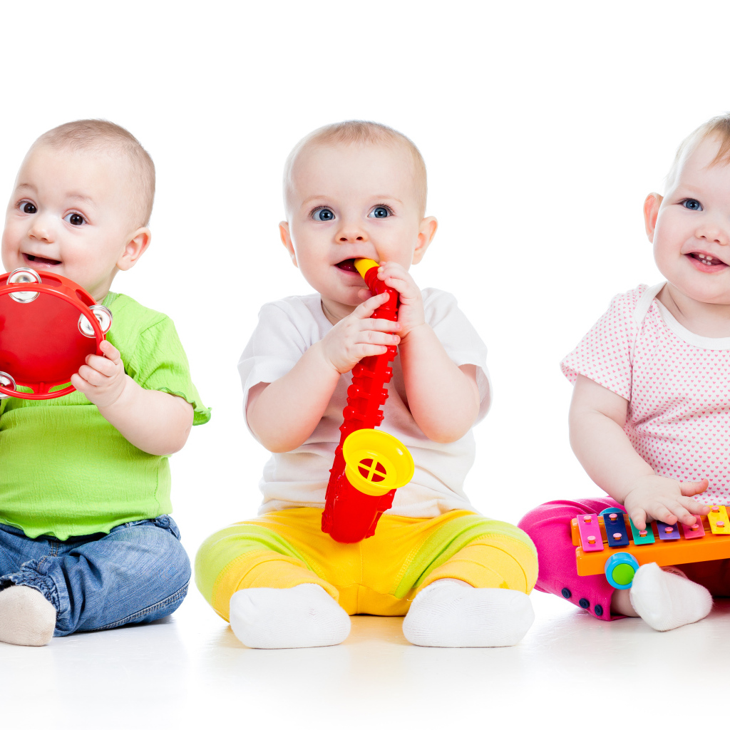 Три улыбающихся младенца играют на белом фоне