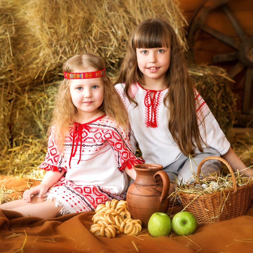 Две маленькие девочки в красивых костюмах с угощениями