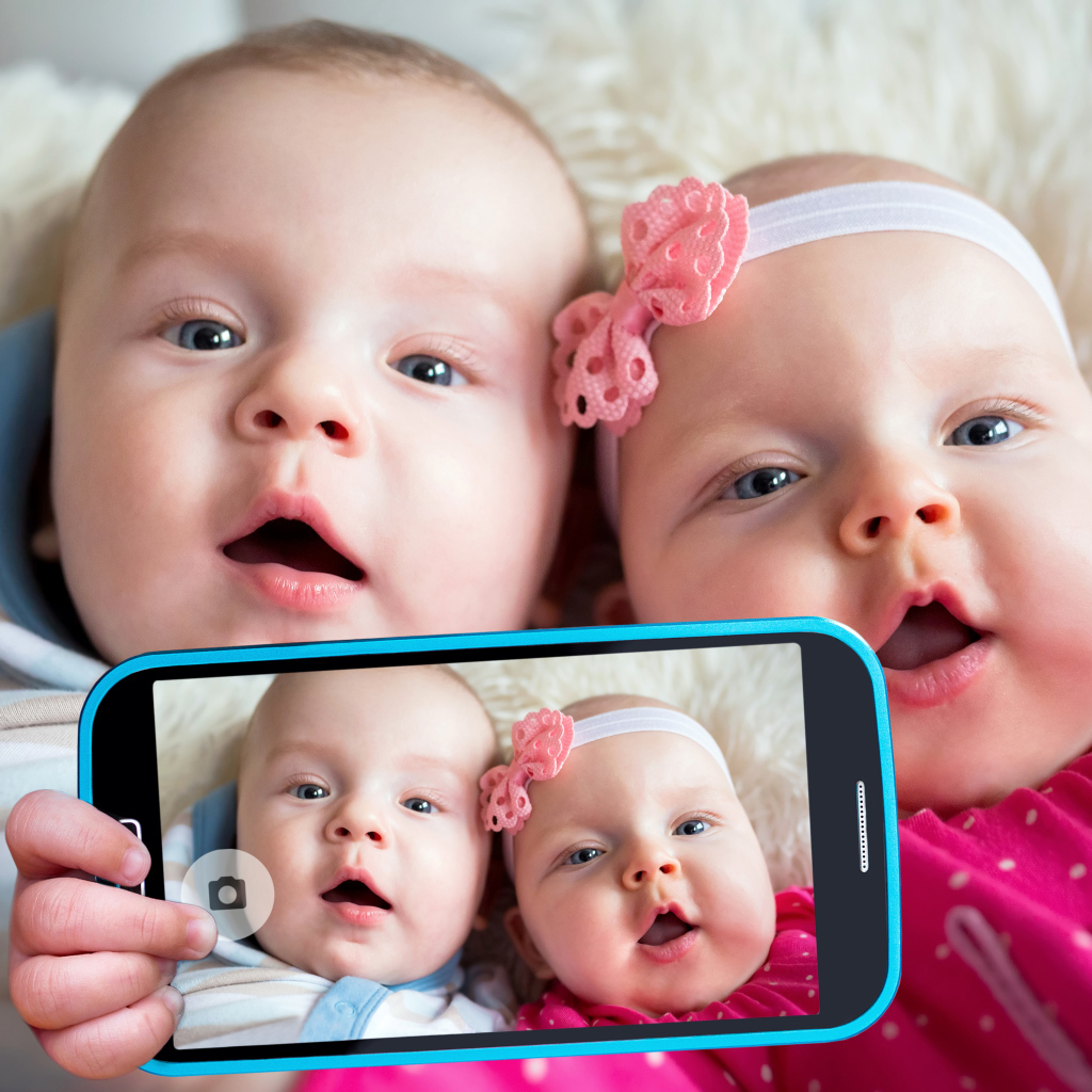 Два маленьких ребенка делают селфи на телефон