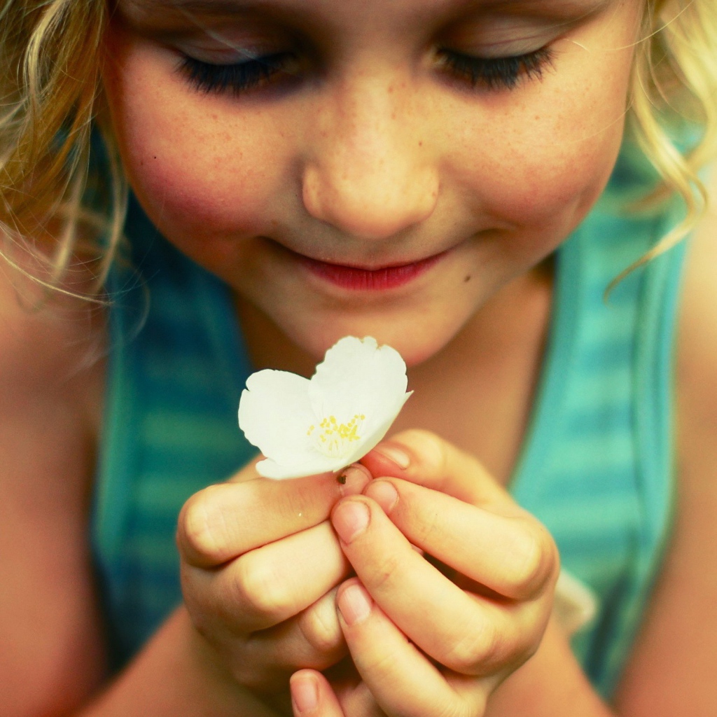 Маленькая девочка  держит белый цветок 