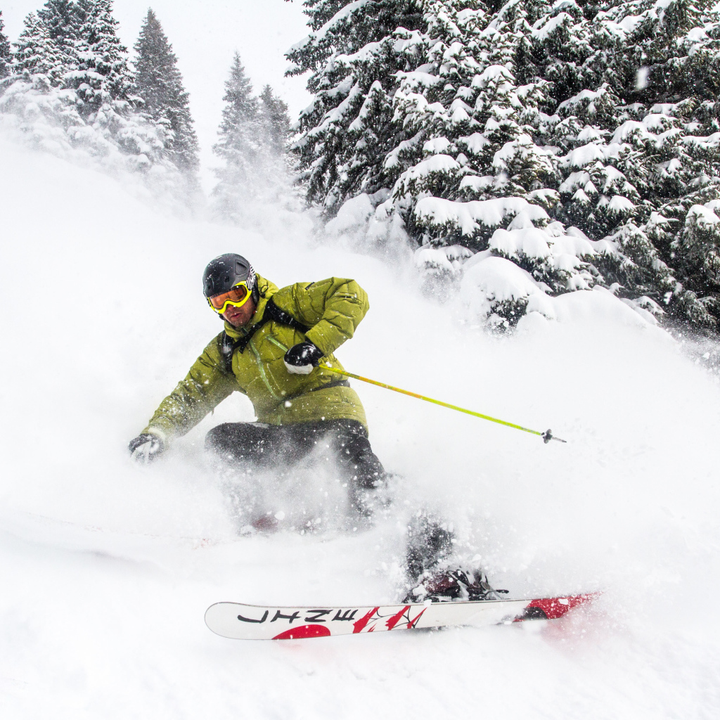 Спортсмен лыжник спускается по заснеженному склону