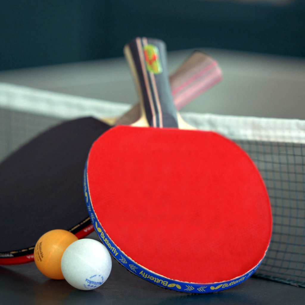 Ракетки для настольного тенниса и мячи на столе  