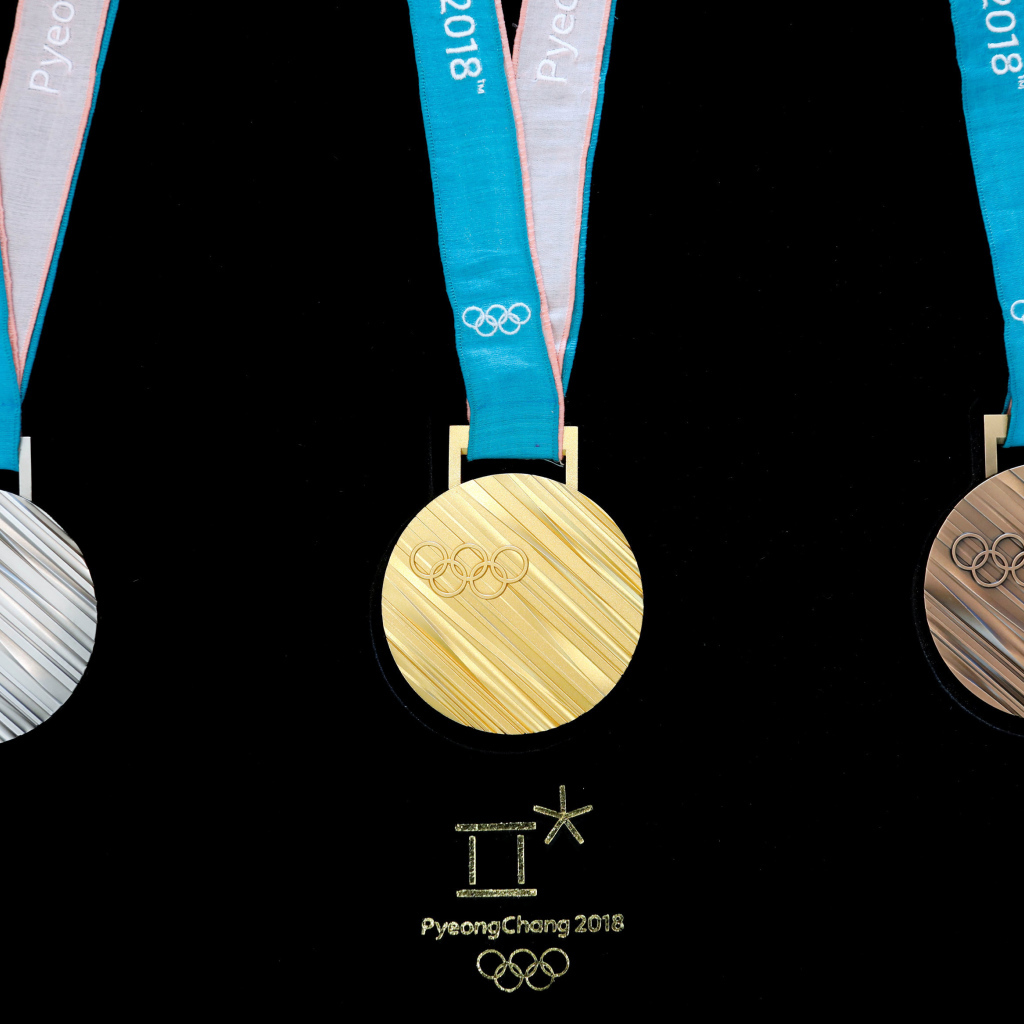 Три медали зимних Олимпийских игр 2018 на черном фоне