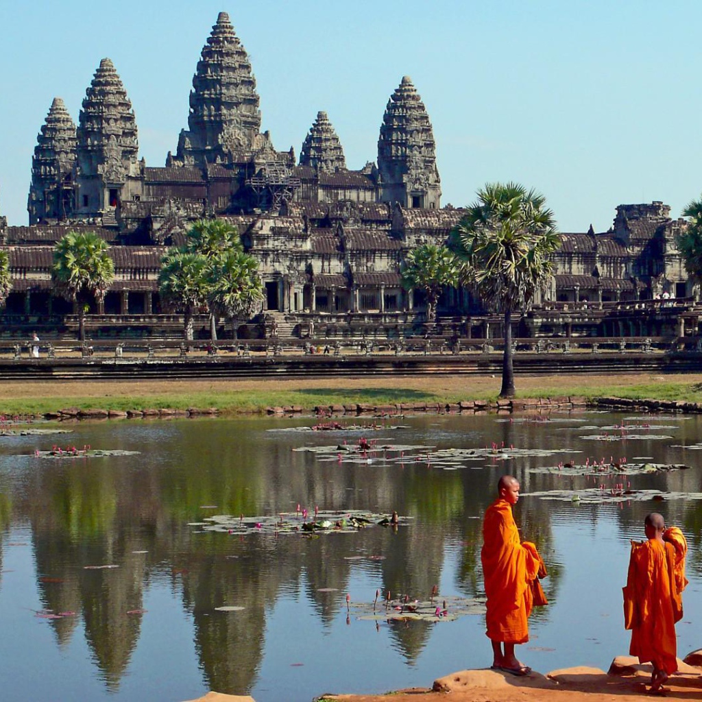 Монахи на берегу водоема у храмового комплекса Ангкор Ват 