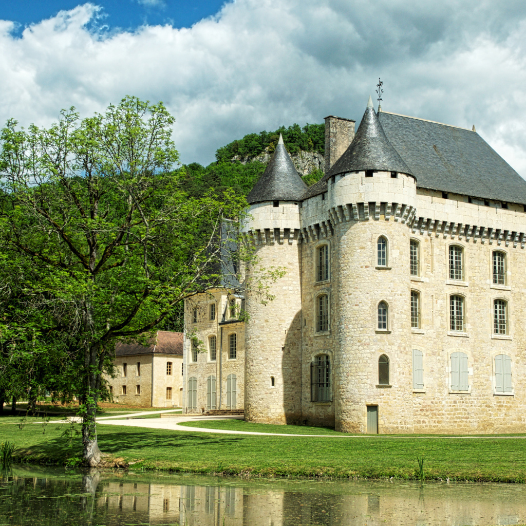 Старинный замок у пруда в зеленом саду, Франция