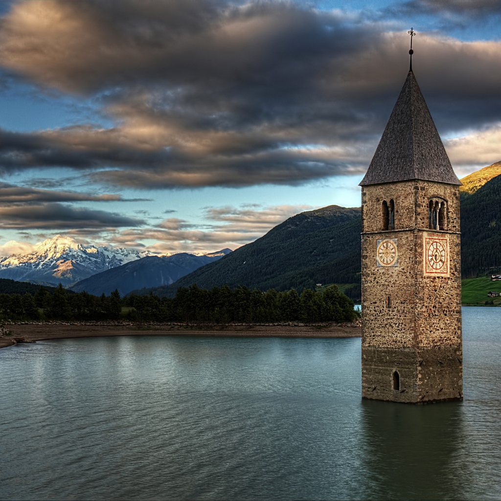 Старинная часовня на фоне красивого неба посреди озера Резия, Италия