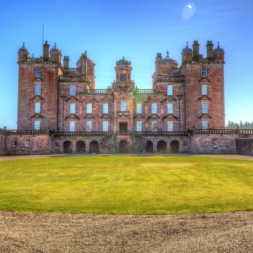 Замок Drumlanrig Castle с зеленым  газоном, Шотландия 