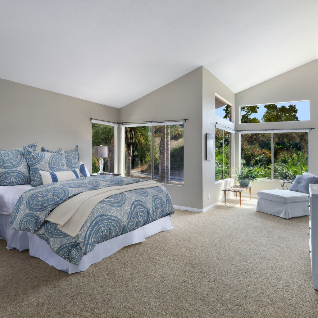 Уютная спальная комната в серых тонах с большими окнами