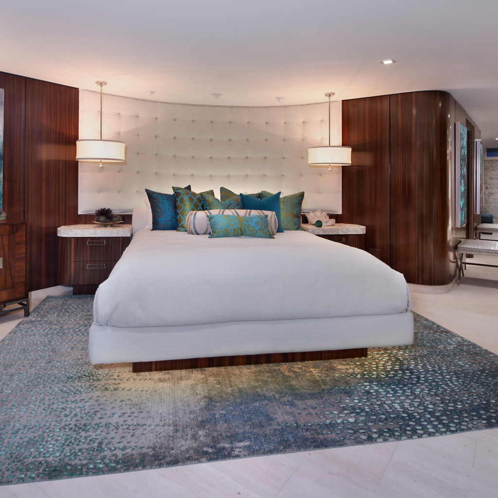 Большая кровать с белым покрывалом в спальне в коричневых тонах