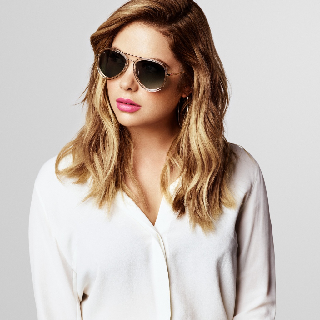 Актриса Эшли Бенсон в черных очках на сером фоне