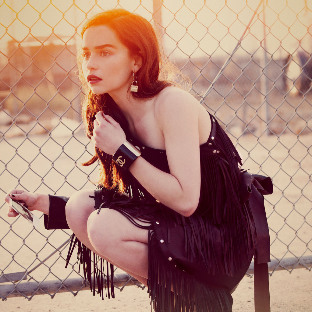 Актриса Эмилия Кларк в красивом черном платье в лучах солнца