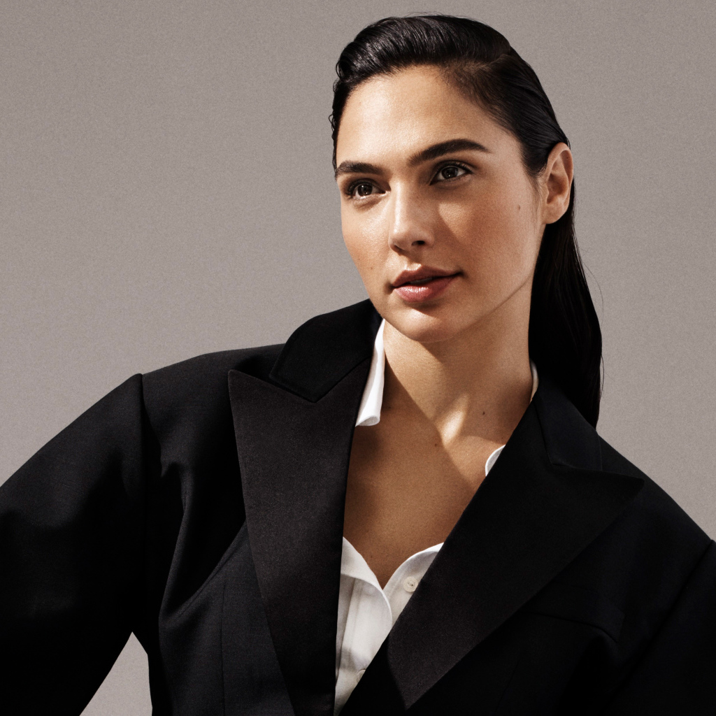 Актриса Галь Гадот в черном пальто на сером фоне