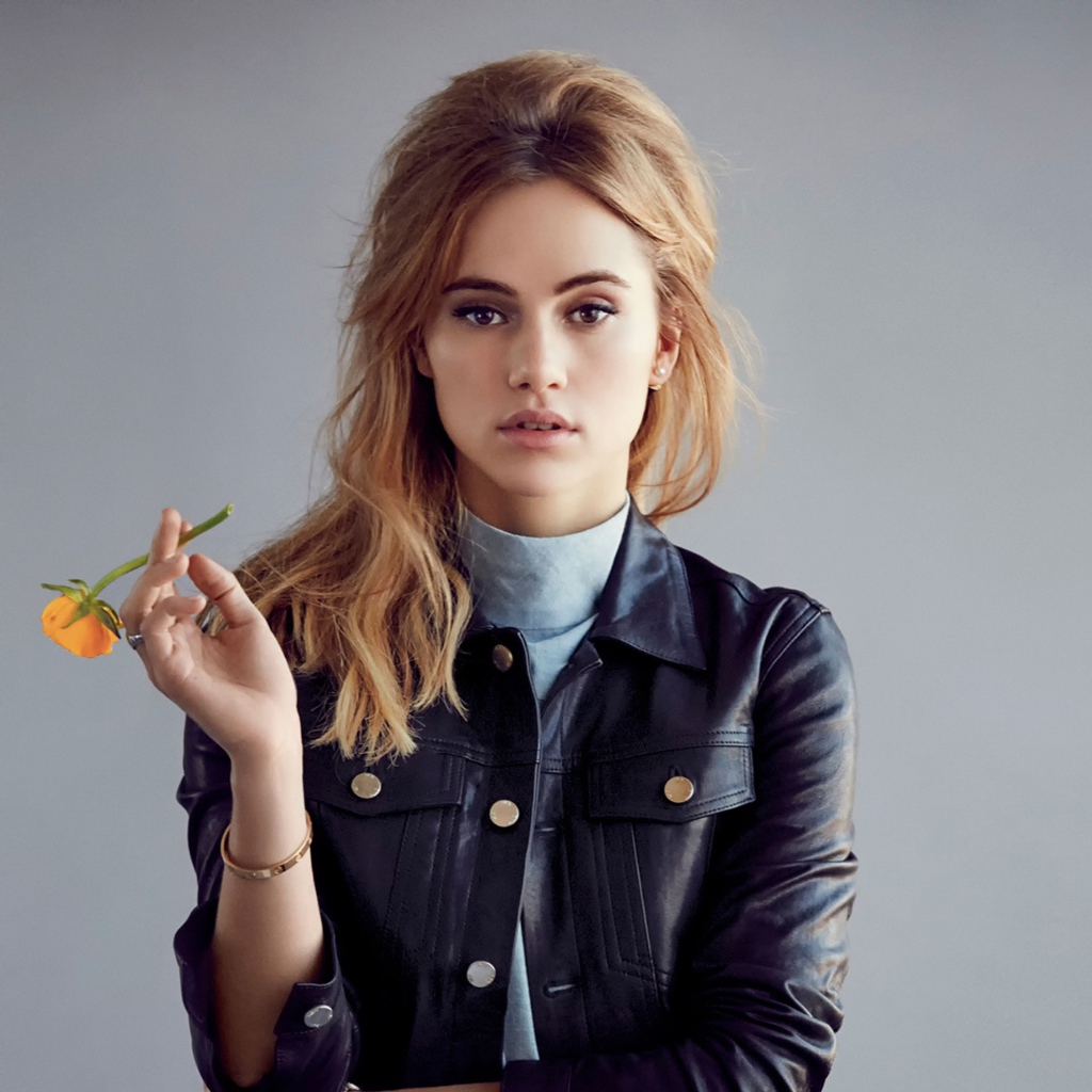 Актриса Сьюки Уотерхаус с цветком в руках на сером фоне
