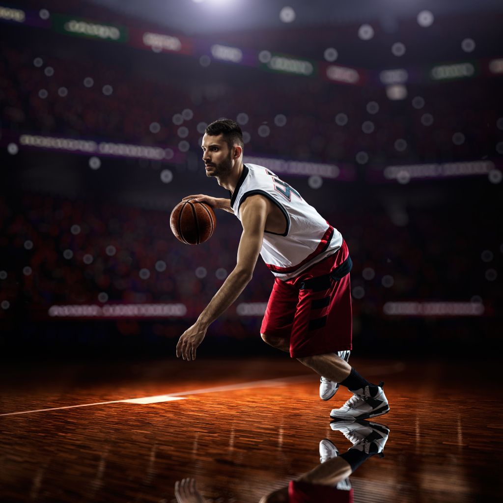 Баскетболист с мячом играет на поле