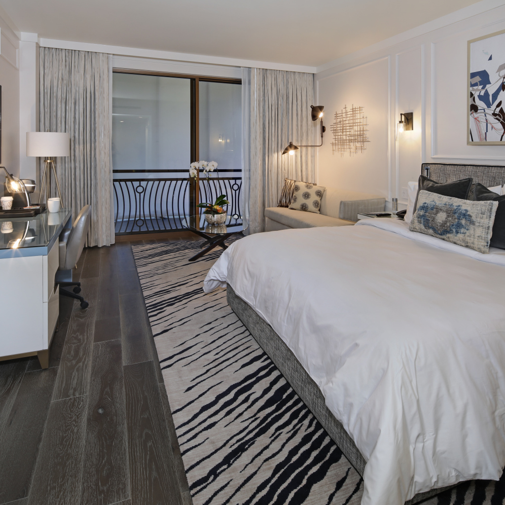 Спальня с большой кроватью и телевизором на стене