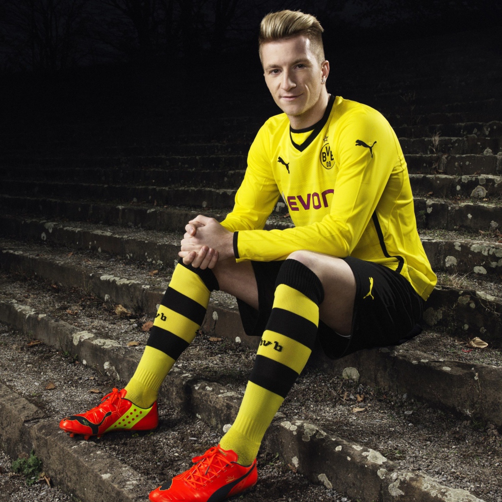 Немецкий футболист Марко Ройс сидит на ступеньках 