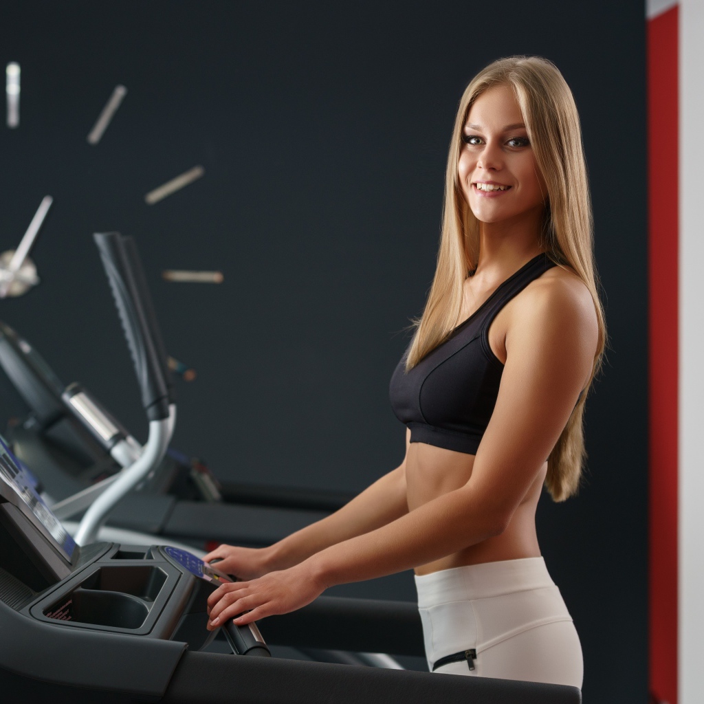 Девушка спортсменка на беговой дорожке 