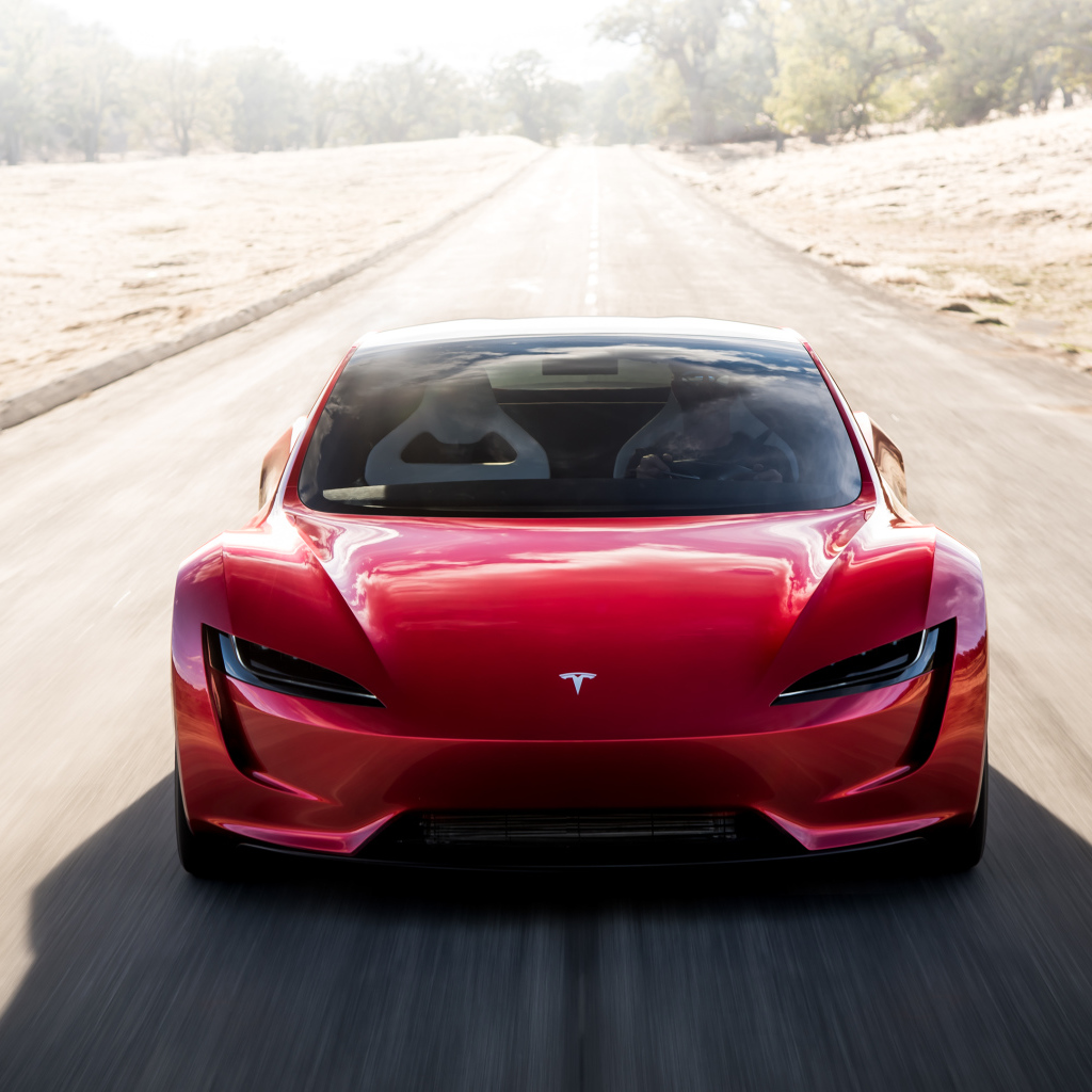 Красный автомобиль Tesla Roadster на трассе, вид спереди