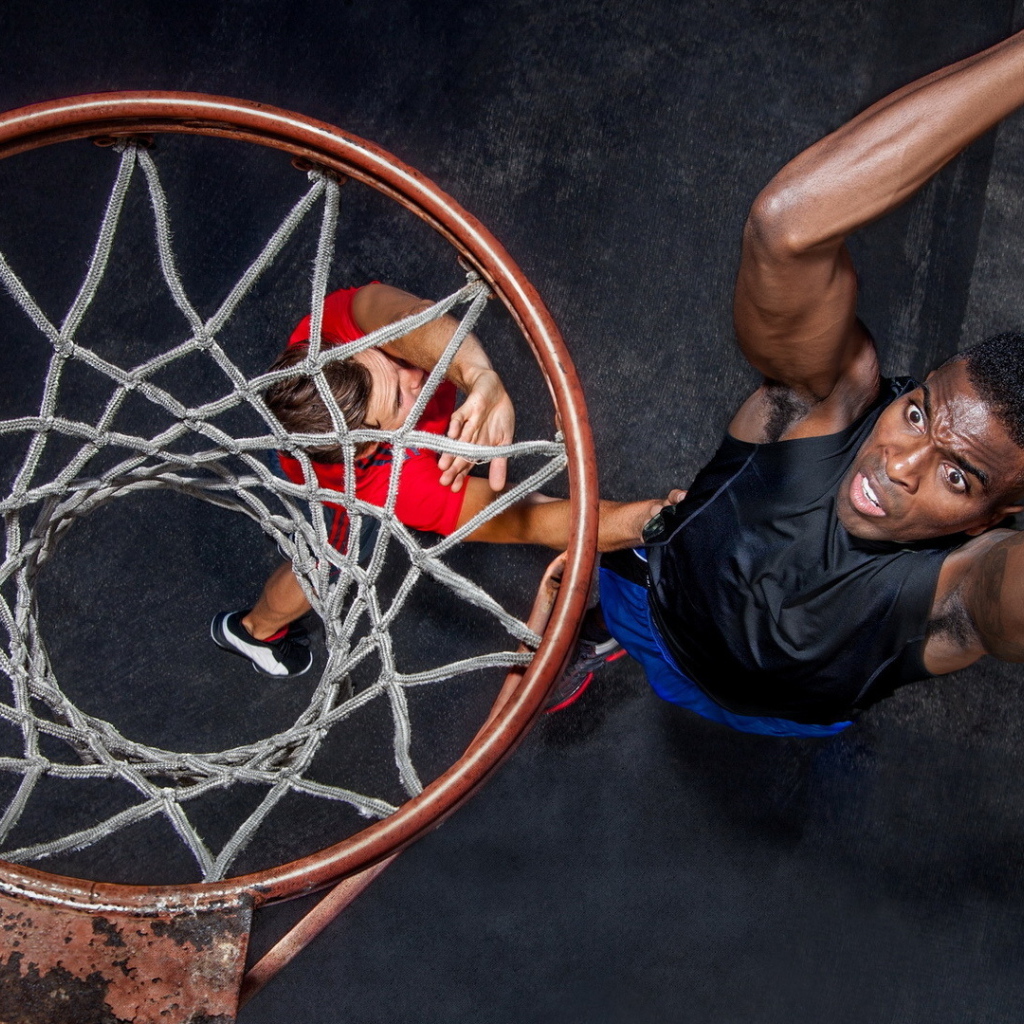 Баскетболист забрасывает мяч в кольцо 