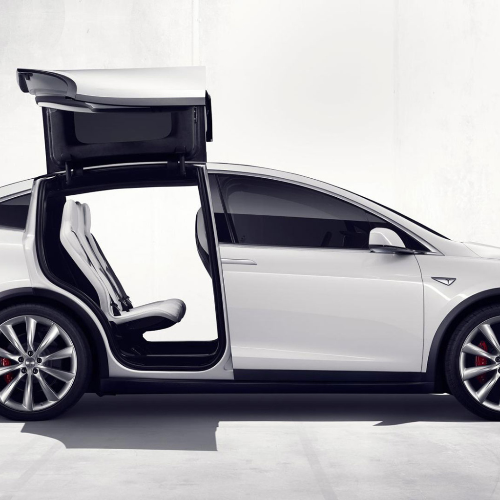 Белый электромобиль Тесла с открытыми дверями  