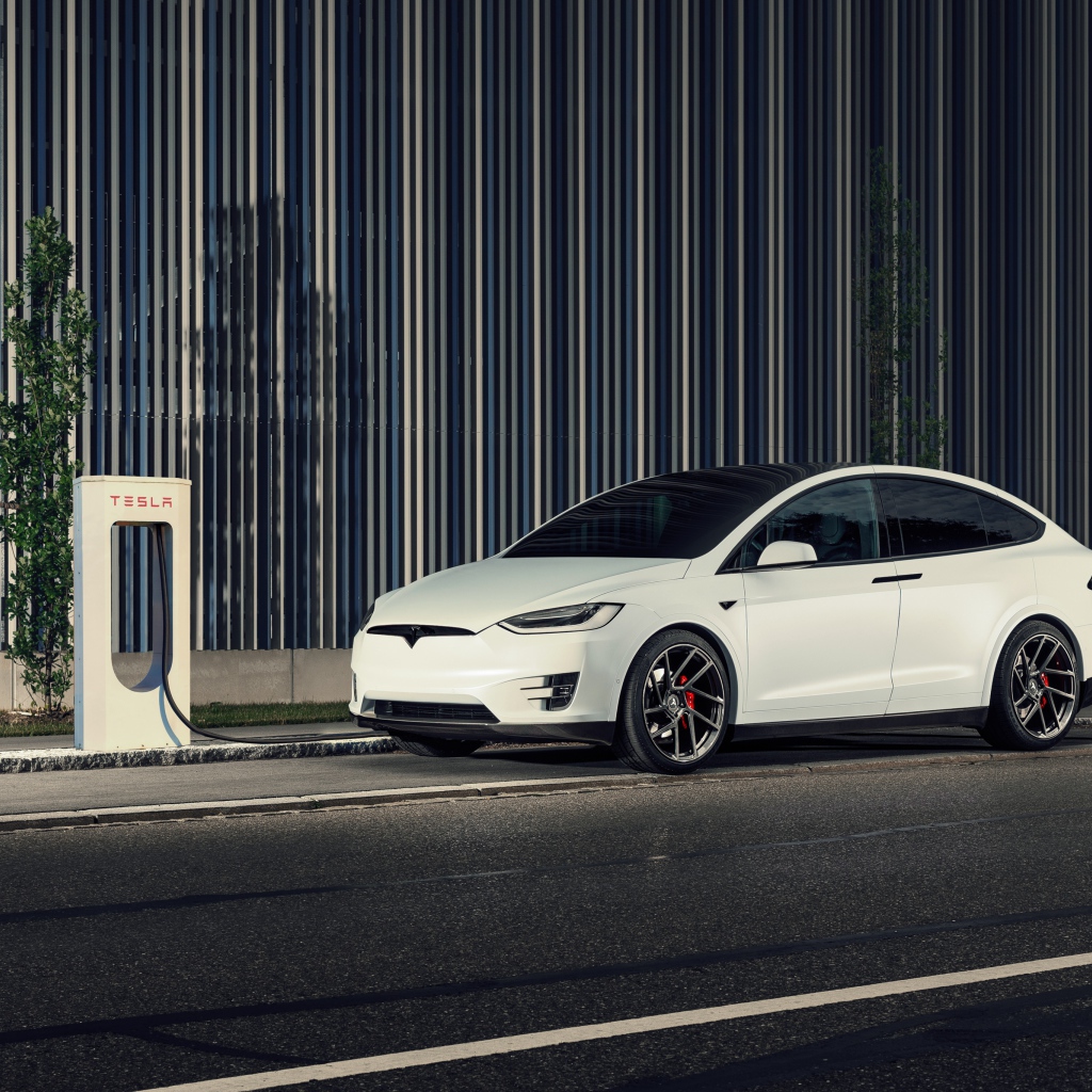 Белый электрокар Tesla Model X на заправке