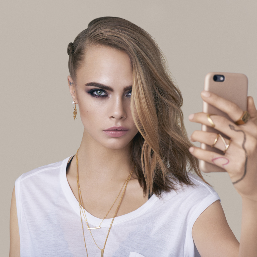 Молодая актриса Кара Делевинь с телефоном в руках