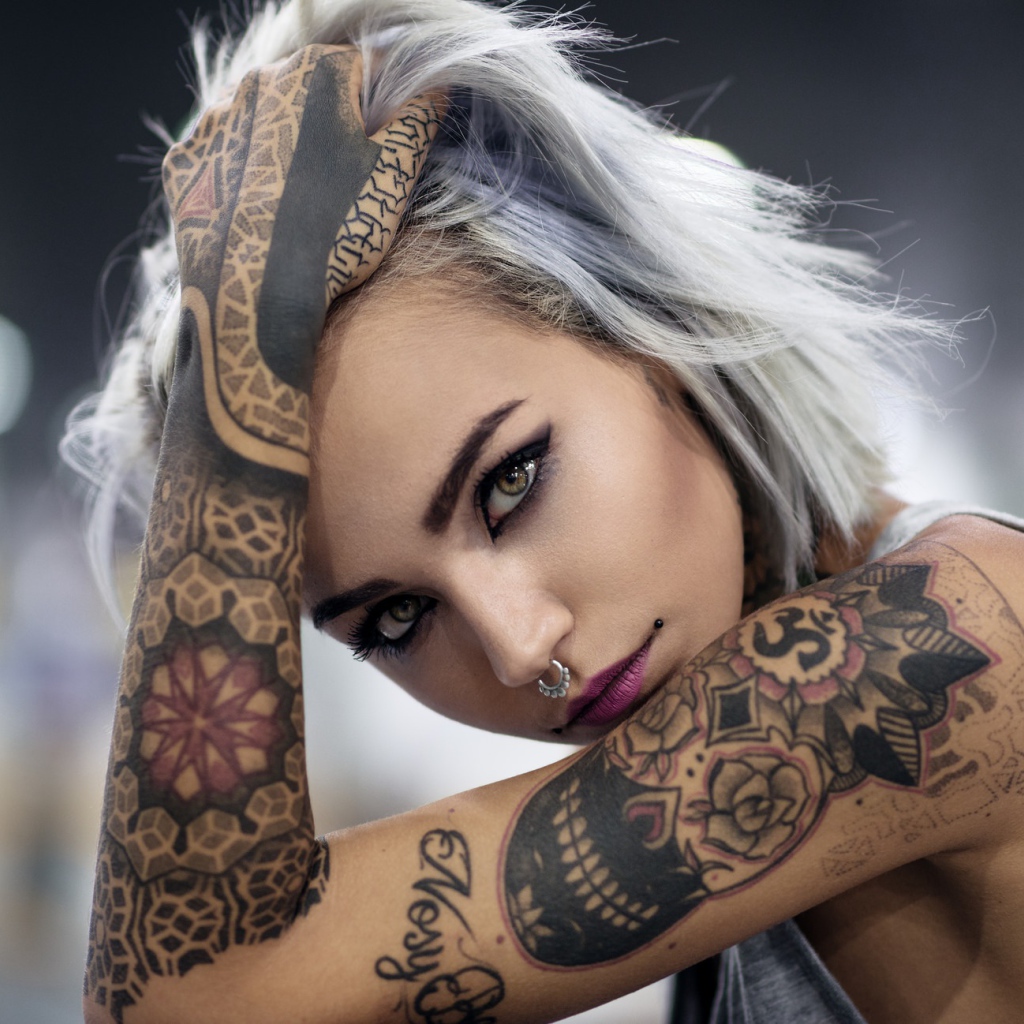 Молодая девушка с татуировками на теле 