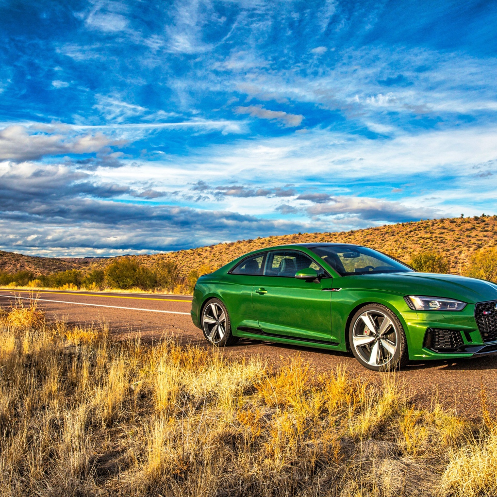 Зеленый автомобиль Audi RS5 на фоне красивого неба 