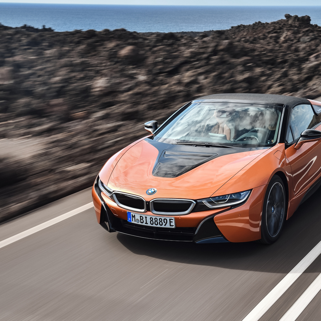 Оранжевый автомобиль BMW i8 Roadster, 2018 на скорости